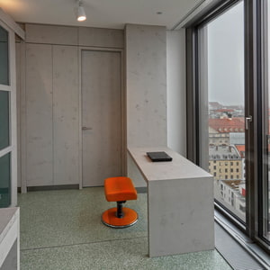 Arbeitsplatz mit Aussicht. Schreibitsch, Wandverkleidung, Tür und Bank aus imi-beton PLUS Glattschalun grau