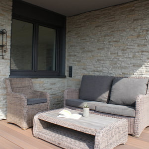 Terrasse mit Gartengarnitur bestehend aus Stuhl, Bank und Tisch in hellbrauch; Wandverkleidung in imi monyt Steinpaneel 2000