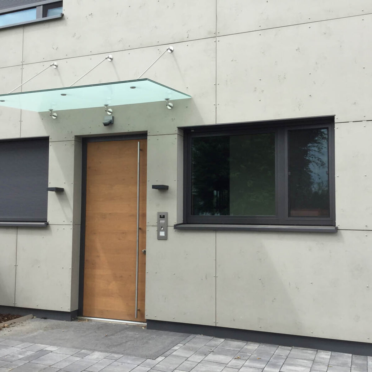 Detailbild Hauseingang mit Fassade aus imi-Fassade Glattschalung grau