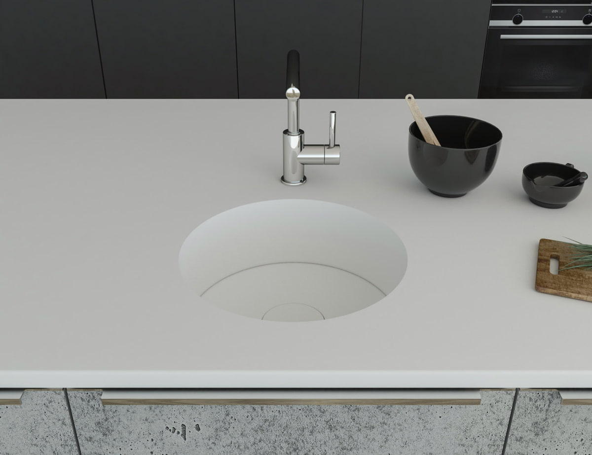 Küchenspüle rund PRSE380, Durchmesser 404 mm aus dem Mineralwerkstoff Staron in der Farbe Bright White mit einem Spülenboden und Designabdeckung aus Staron Bright White. Die Spüle wurde in eine Arbeitsplatte auch aus Staron Bright White fugenlos eingebaut