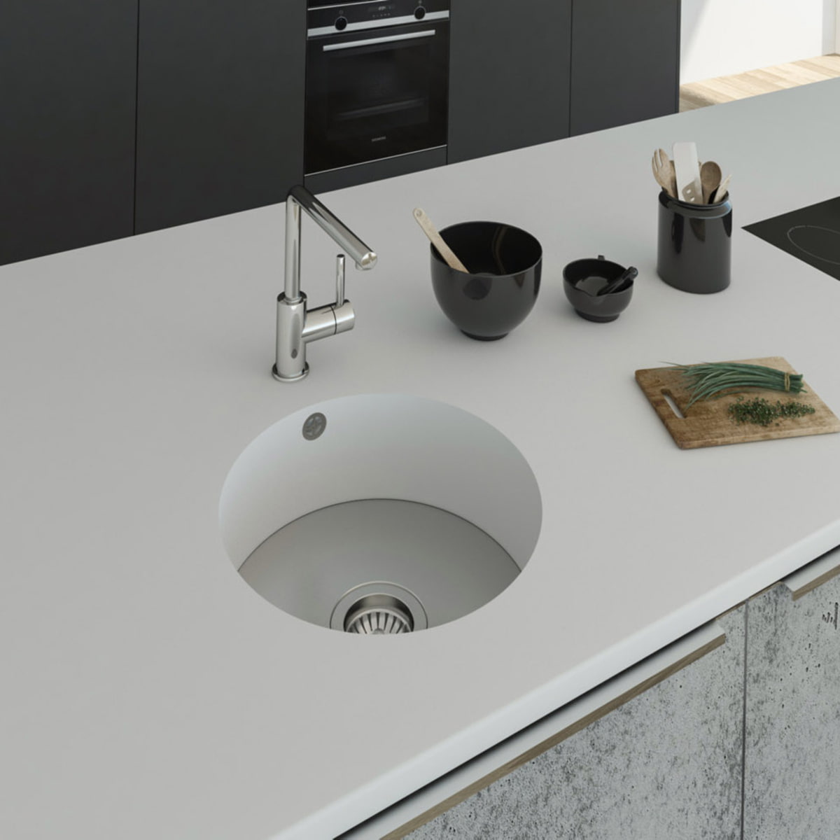 Küchenspüle rund PRSE380, Durchmesser 404 mm aus dem Mineralwerkstoff Staron in der Farbe Bright White mit einem Spülenboden aus Edelstahl und einer Ablaufgarnitur. Die Spüle wurde in eine Arbeitsplatte auch aus Staron Bright White fugenlos eingebaut. 